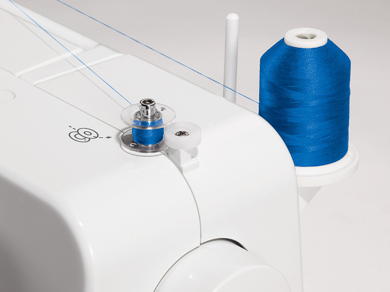 Close up of a bobbin winding royal blue thread on a SINGER 1409 Promise sewing machine