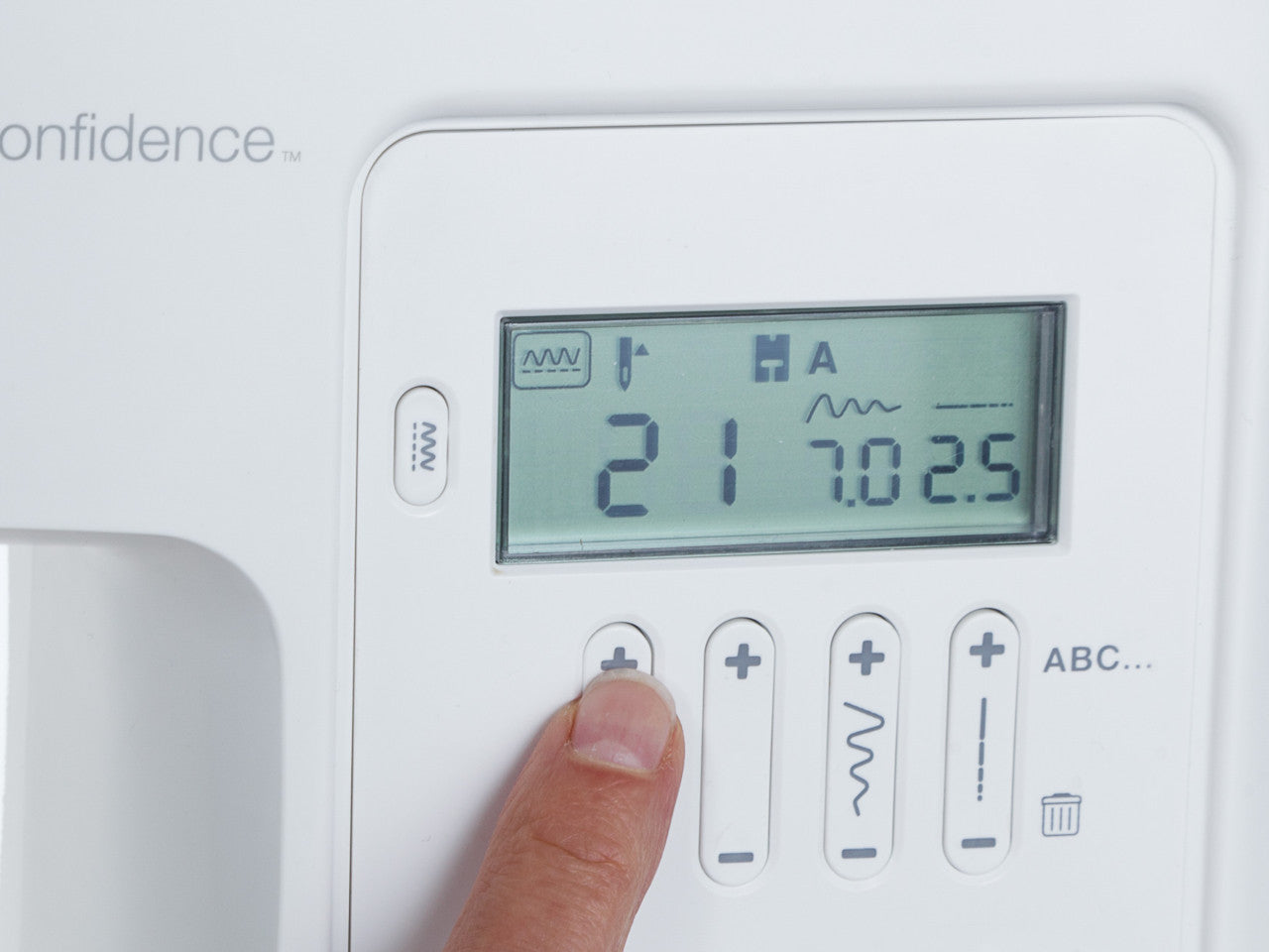 Close up of finger pointing to an LCD display on a SINGER 7640 Easy Touch sewing machine