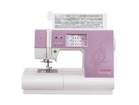 The open top lid of the SINGER Quantum Stylist 9985 sewing machine displays the multiple stitch selections