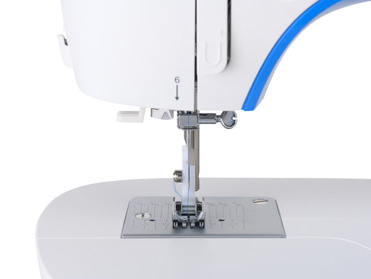 Close up of a needle plate on a white SINGER M3205 sewing machine with blue accent.